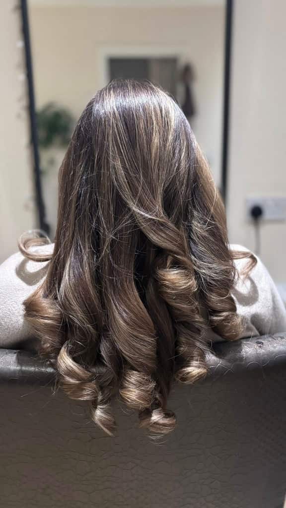 Long highlighted hair styled in voluminous spiral curls