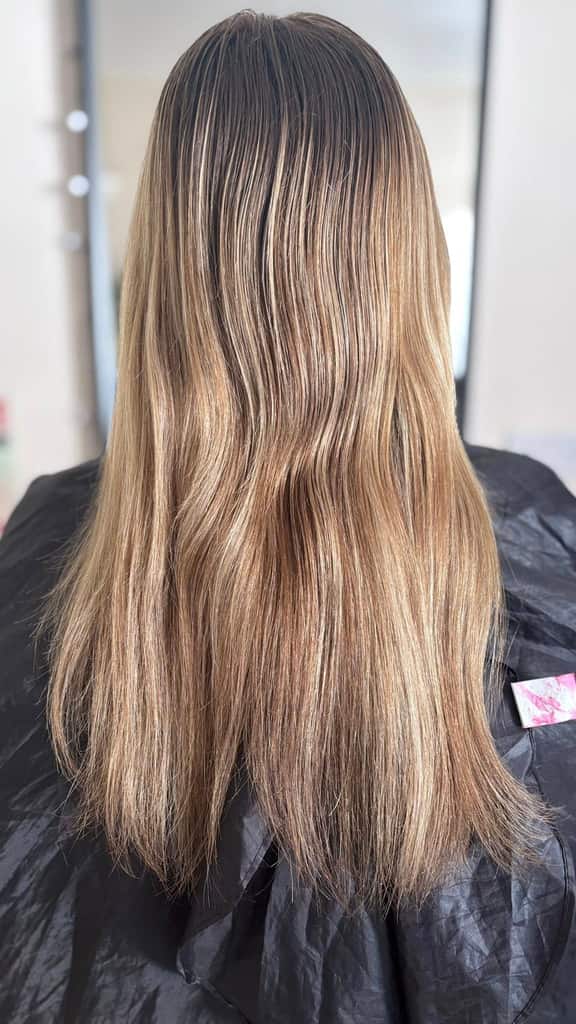 Long balayage from brunette roots to sandy-blonde lengths