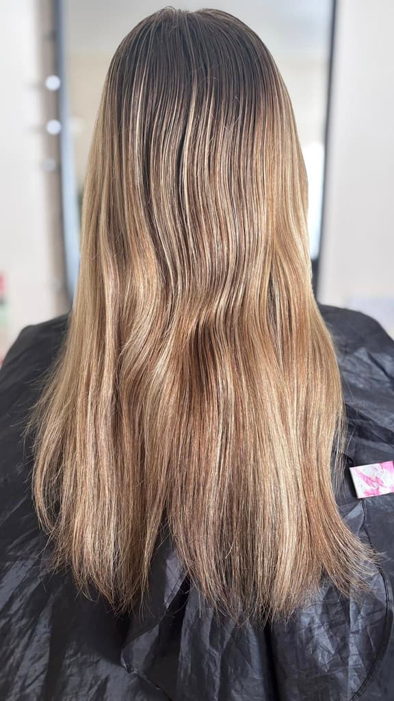 Long balayage from brunette roots to sandy-blonde lengths