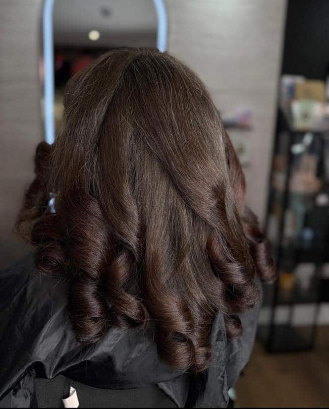 Medium-length brown hair styled in bouncy curls