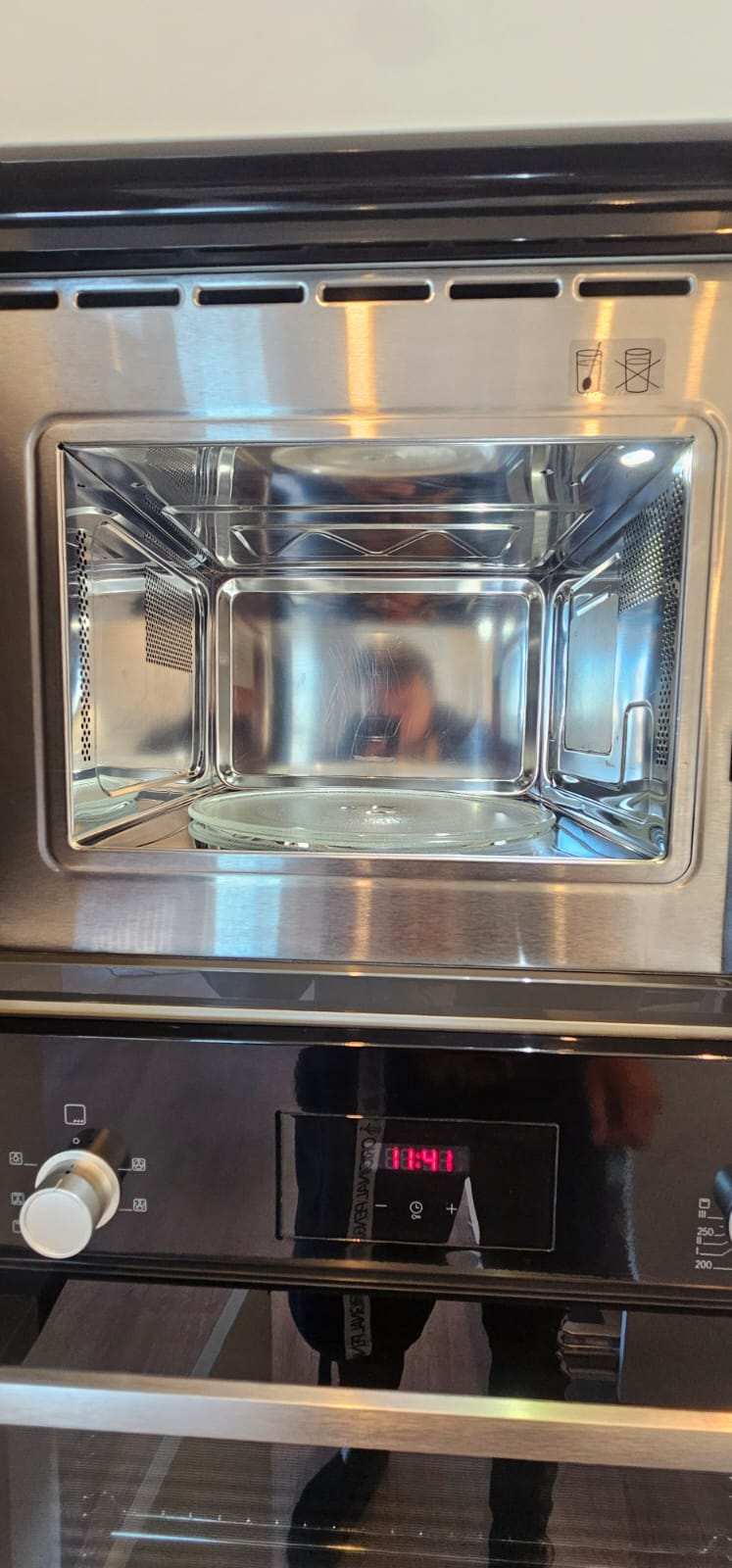 Sparkling clean stainless steel interior of a built-in combination microwave oven after cleaning