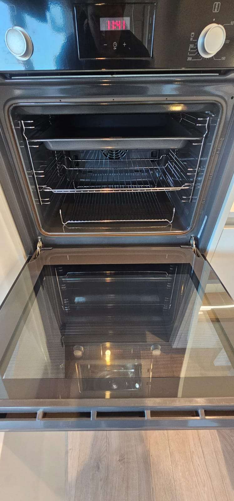 Clean oven interior with spotless racks and the glass door open