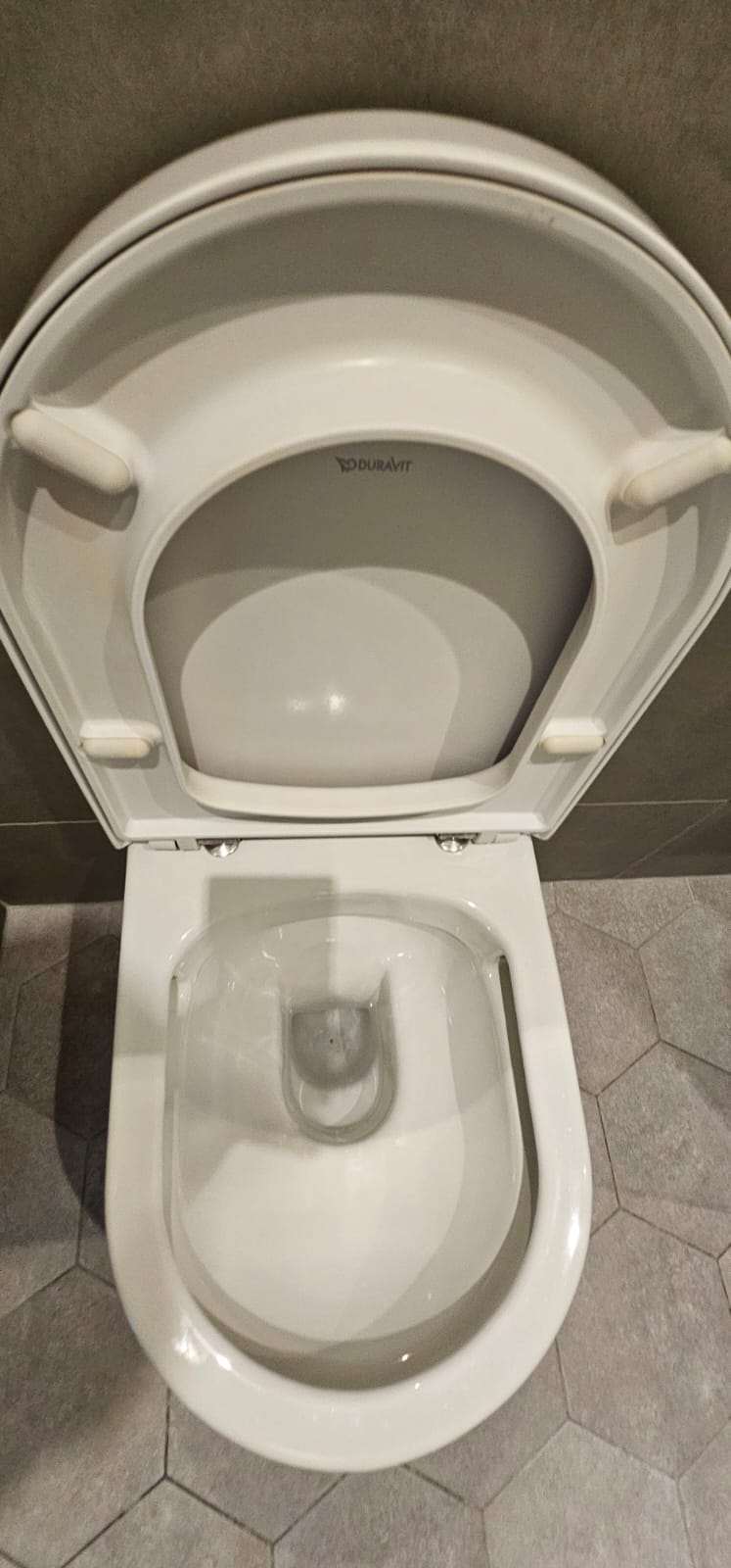 Close-up of a clean white Duravit rimless toilet bowl with the lid open