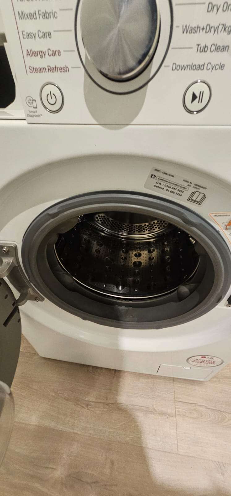 Open front-loading washing machine with a clean stainless steel drum after cleaning