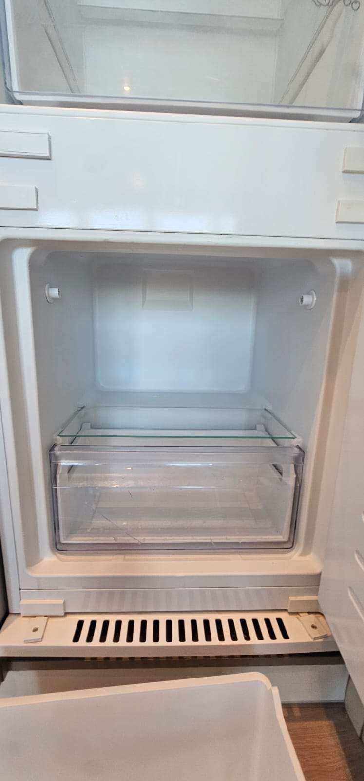 Clean empty fridge-freezer drawer interior after cleaning.