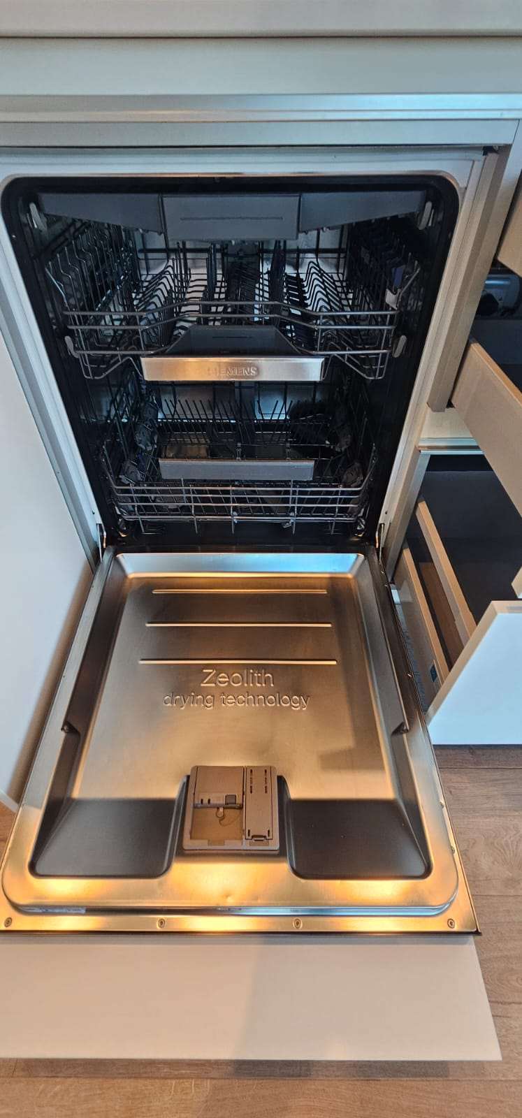 Open dishwasher showing a clean stainless-steel interior