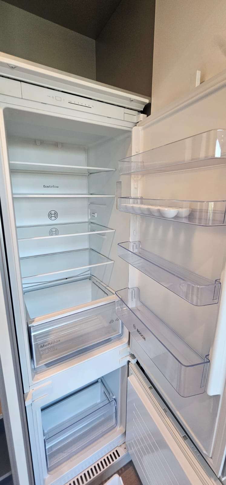 Clean empty Bosch fridge interior with spotless shelves after cleaning.
