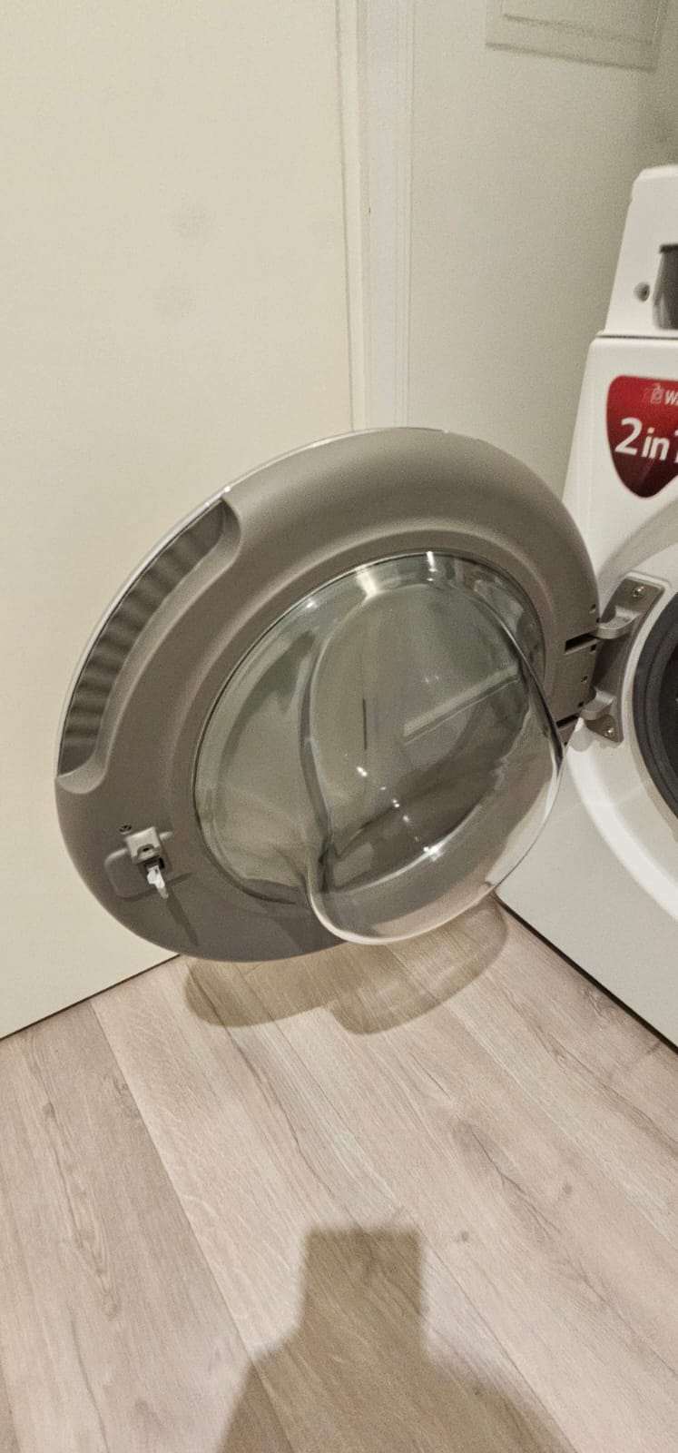 Clean LG washing machine with its door open in a utility area