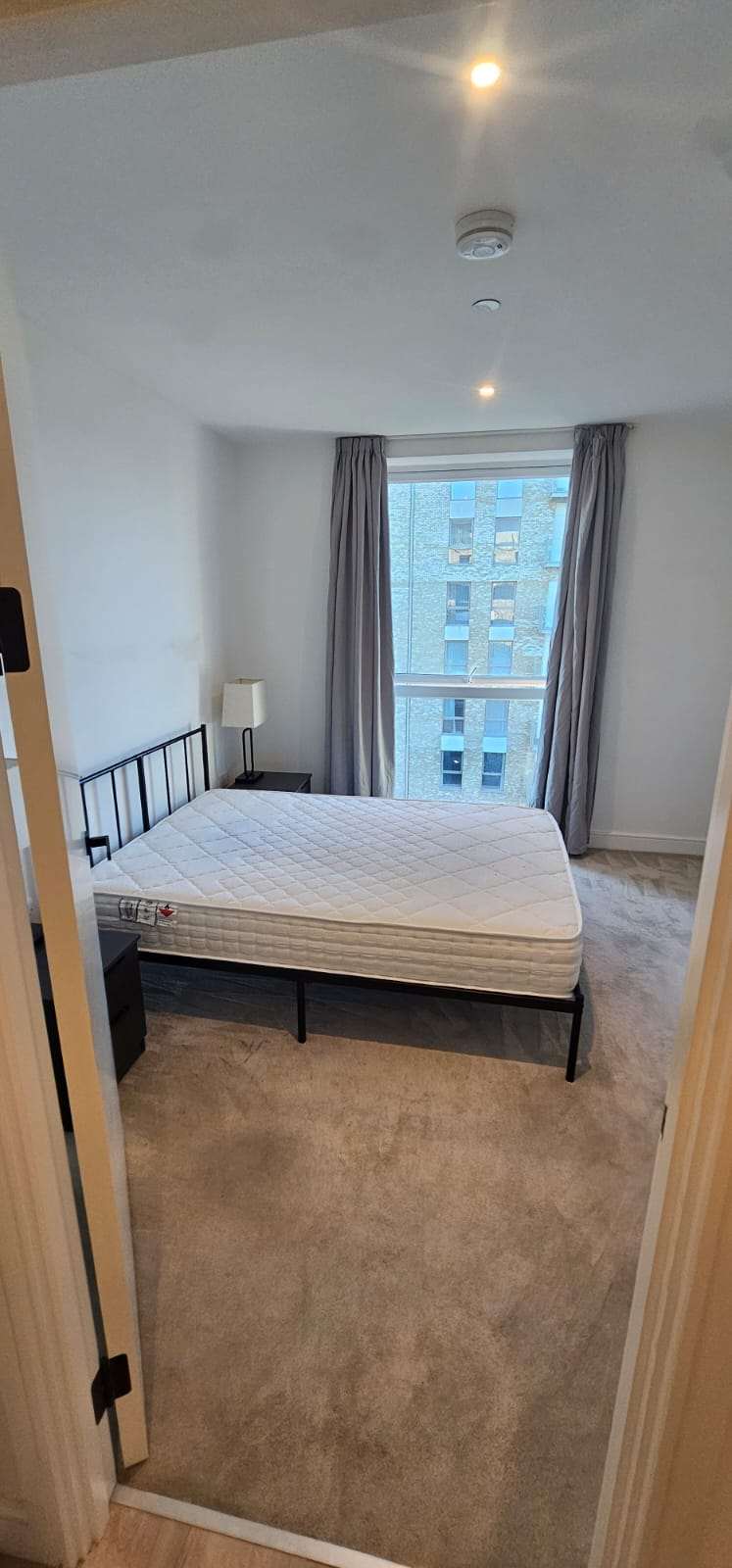 Empty double bedroom with a bare mattress ready for new tenants