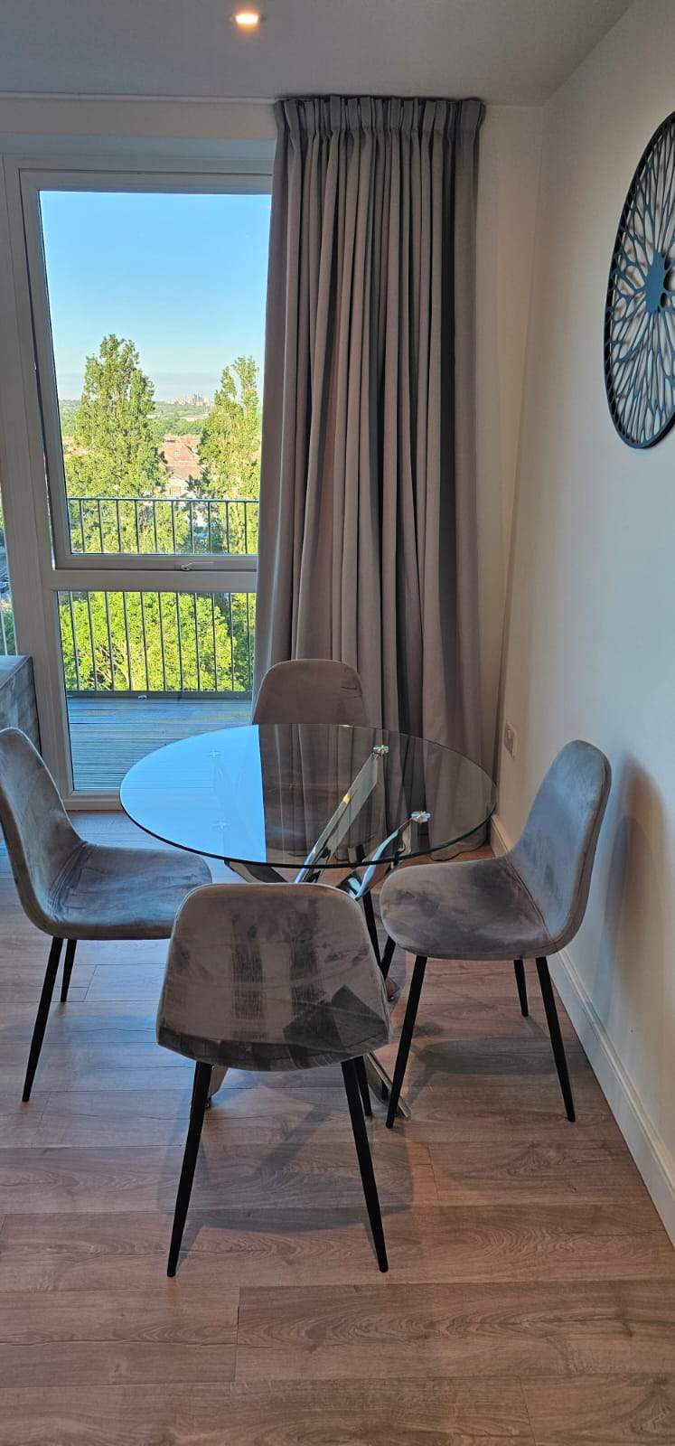 Spotless dining area with a glass table, velvet chairs, and a bright city view through the window, finished by Summa Invest.