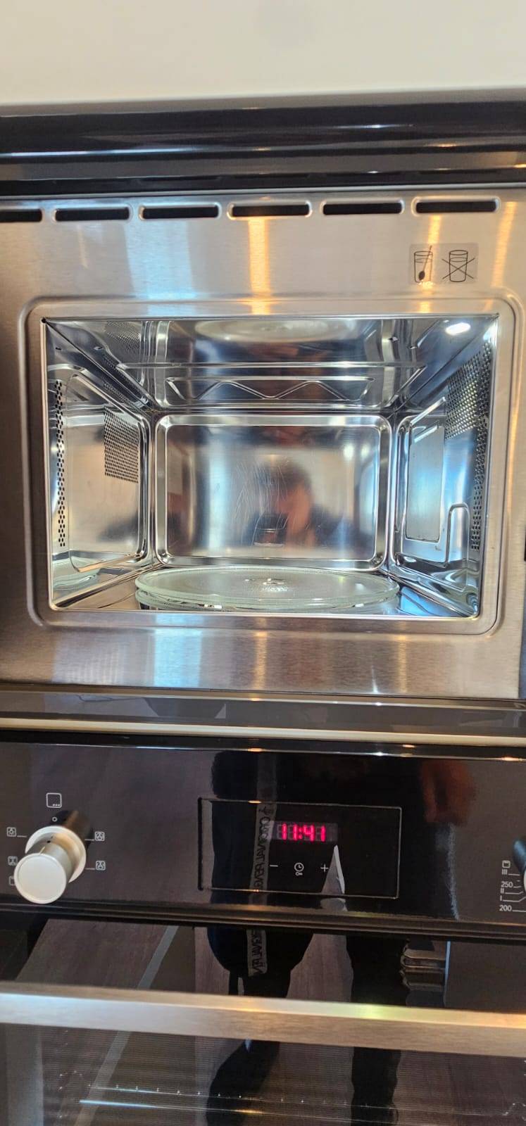Sparkling clean stainless steel interior of a built-in combination microwave oven after cleaning