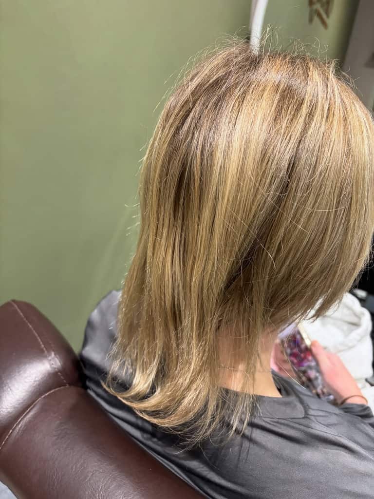 Warm honey-blonde highlights on medium-length hair