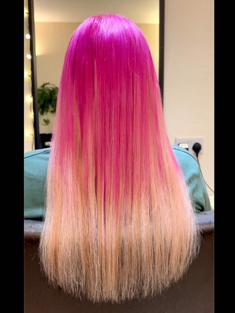 Vivid hot-pink hair melting into platinum blonde ends