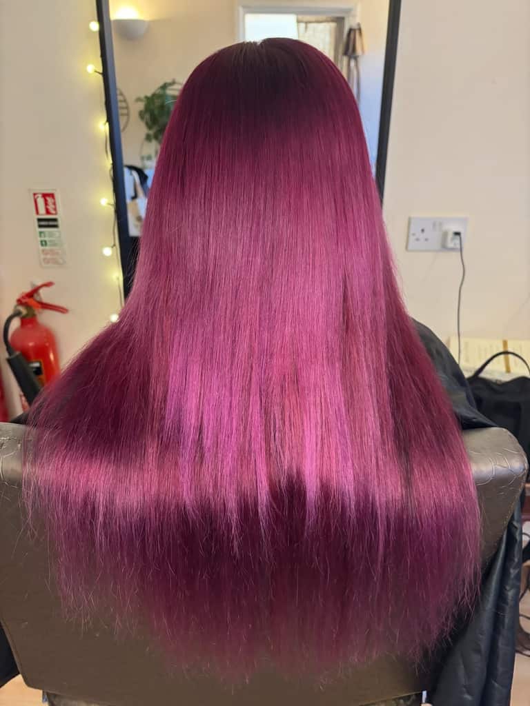 Long hair coloured in vivid magenta with a darker root