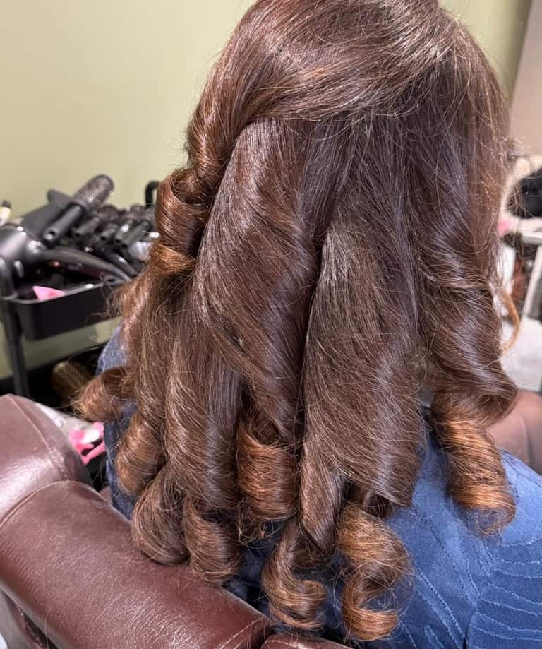 Long hair with caramel highlights styled in glossy ringlet curls