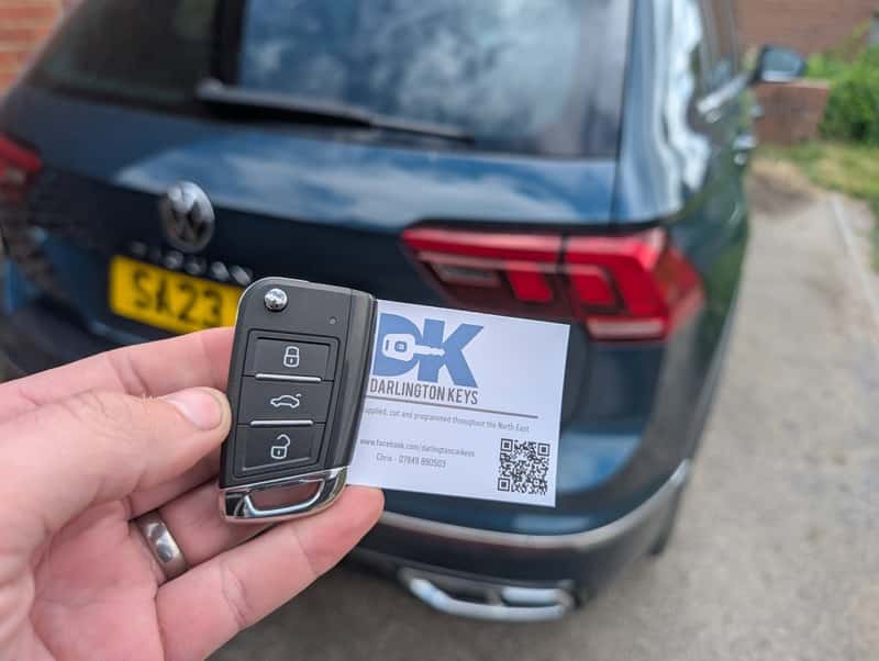 Newly cut Volkswagen replacement key held in front of the customer vehicle