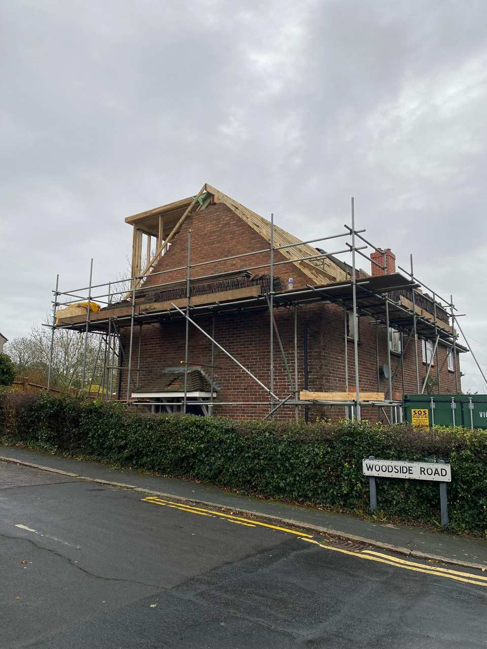 A brick house undergoing loft conversion with new timber dormer framing and scaffolding.