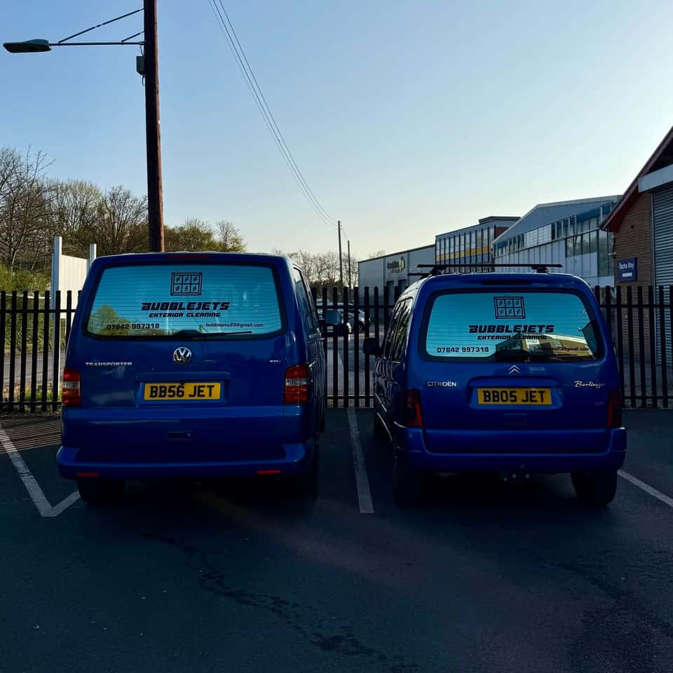Two branded blue Bubble Jets vans parked side by side