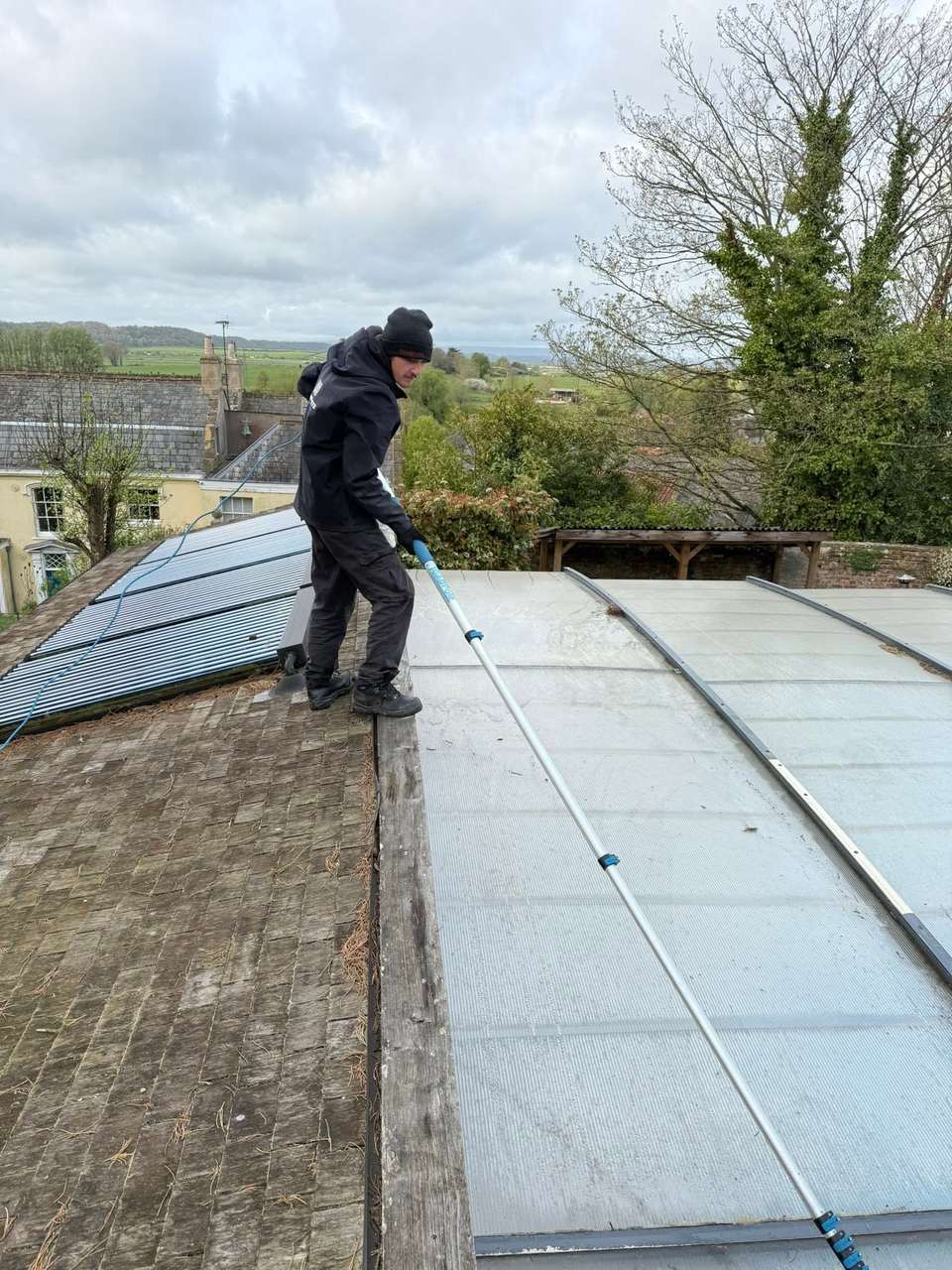 Bubble Jets cleaner using a water-fed pole on a large glazed roof