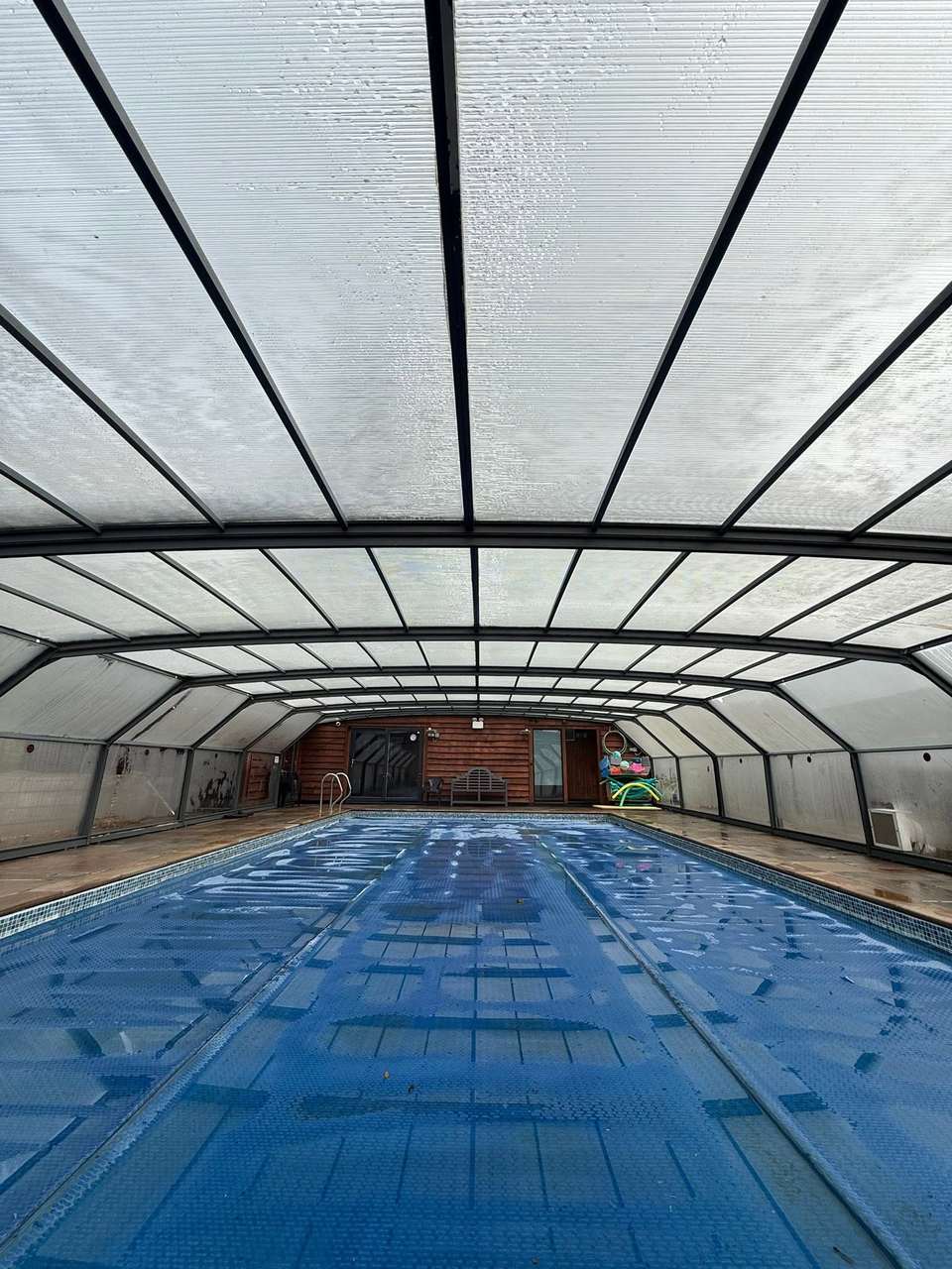 Interior of a pool enclosure with a freshly cleaned glazed roof