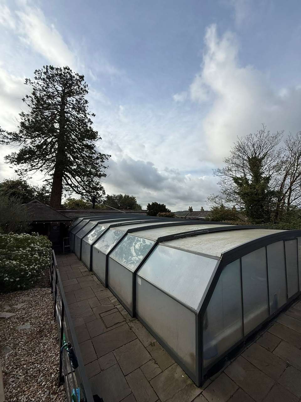 Long curved glazed enclosure roof cleaned clear against a blue sky