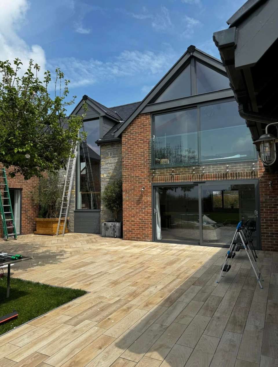 Large gable windows cleaned with a water-fed pole system on a brick home