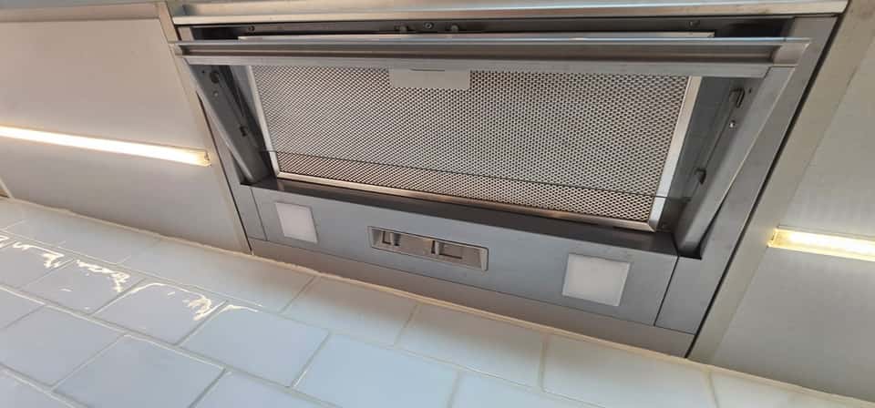 Clean stainless steel cooker extractor hood with a spotless metal grease filter after cleaning