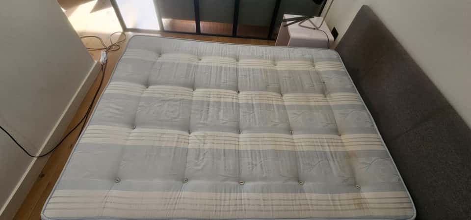 Cleaned grey-and-cream striped double mattress in a bedroom after upholstery cleaning