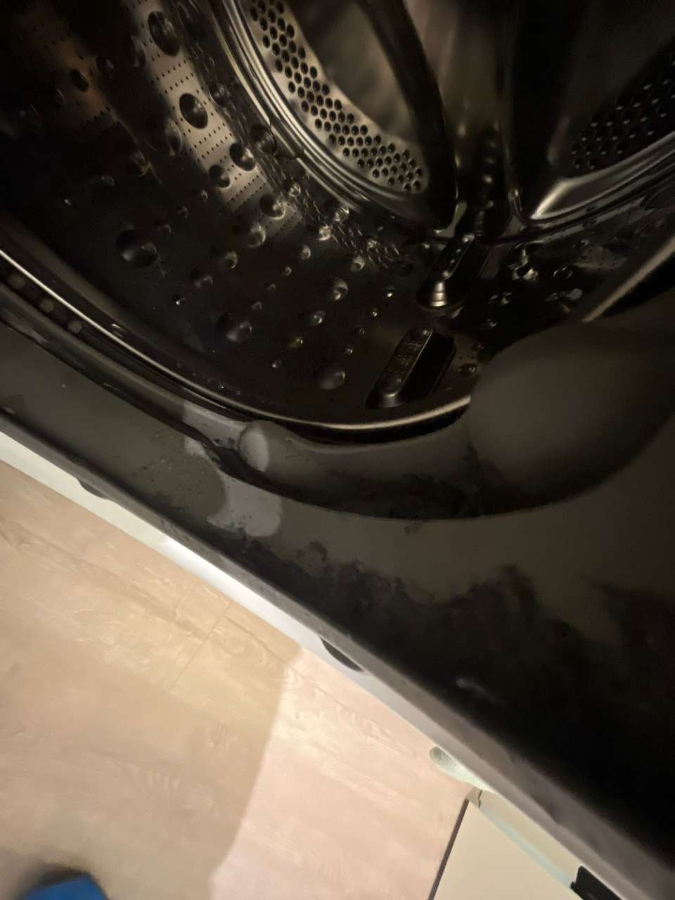 Clean washing machine drum and door seal with water droplets after cleaning