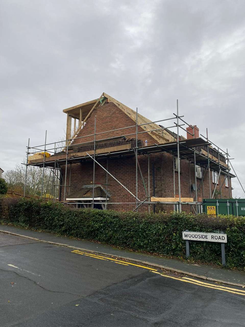 A brick house undergoing loft conversion with new timber dormer framing and scaffolding.