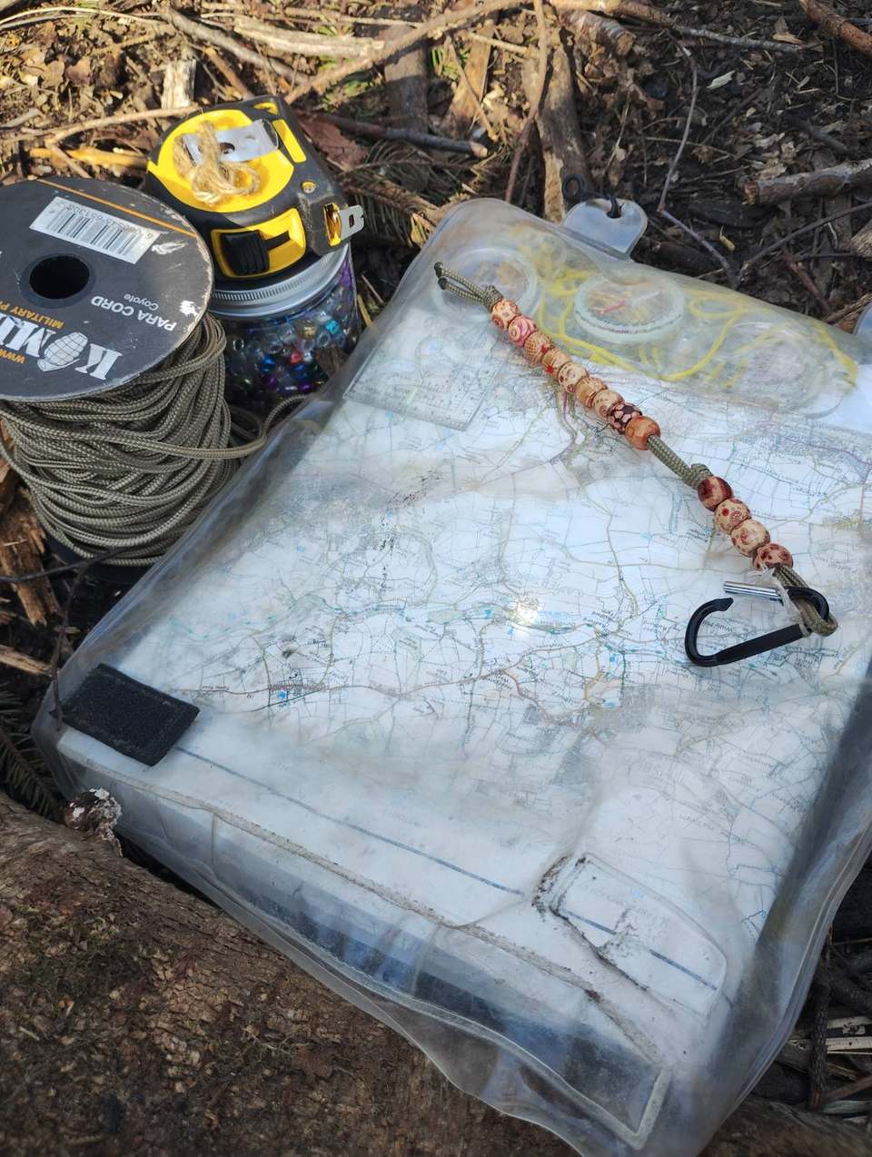 Waterproof map case with paracord and woodland kit