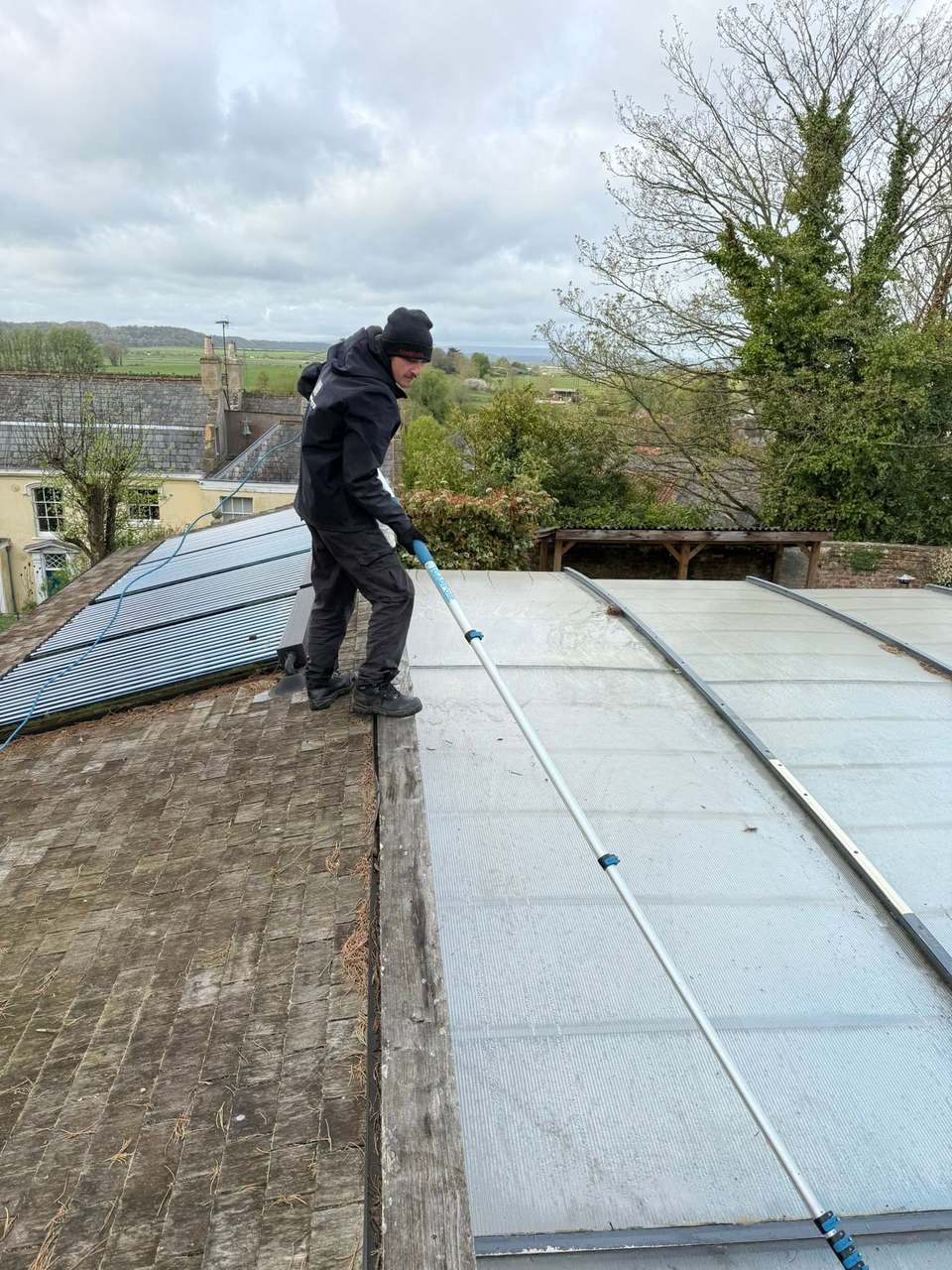 Bubble Jets cleaner using a water-fed pole on a large glazed roof