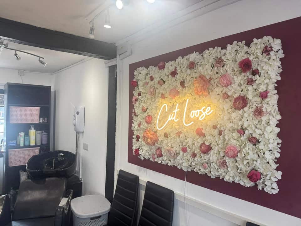 Salon interior with floral feature wall and wash basin in the foreground