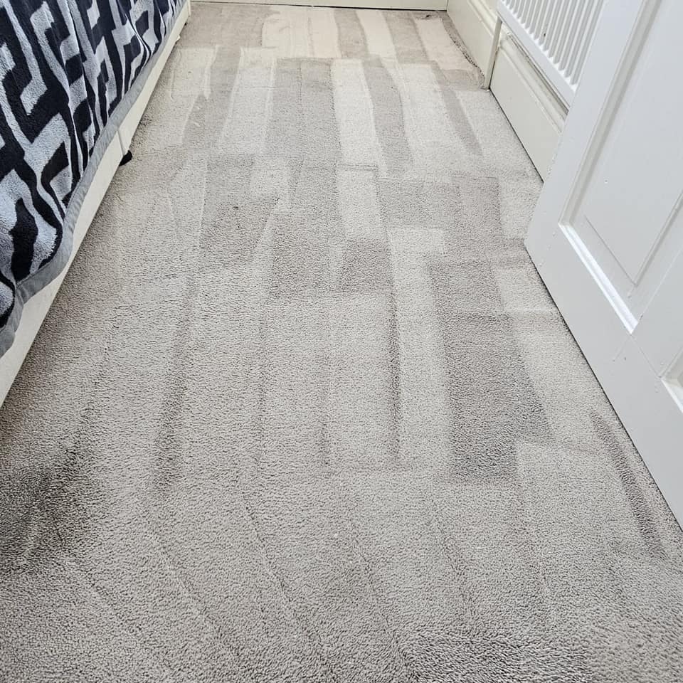 Freshly cleaned grey bedroom carpet showing neat extraction stripes.