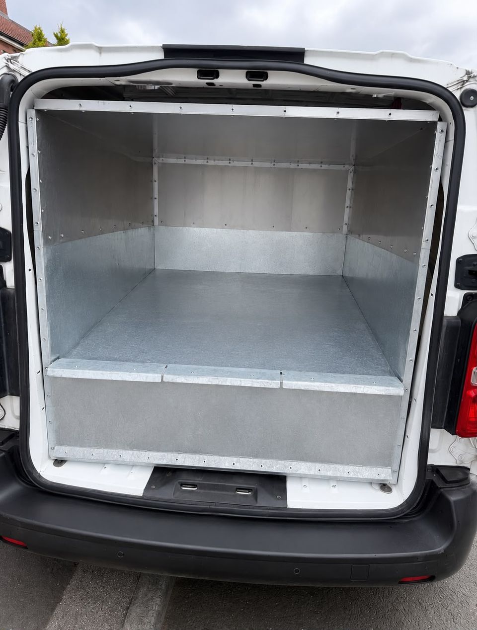 Open rear doors of The BinBusters van showing the clean empty galvanised steel wash bay interior