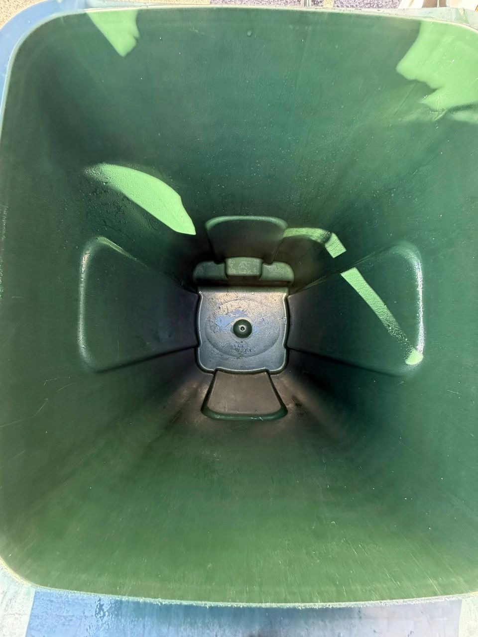 Sparkling interior of a dark green wheelie bin after a professional clean
