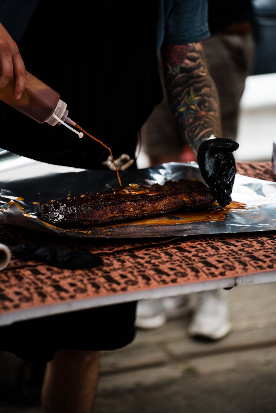 Pitmaster saucing a rack of ribs