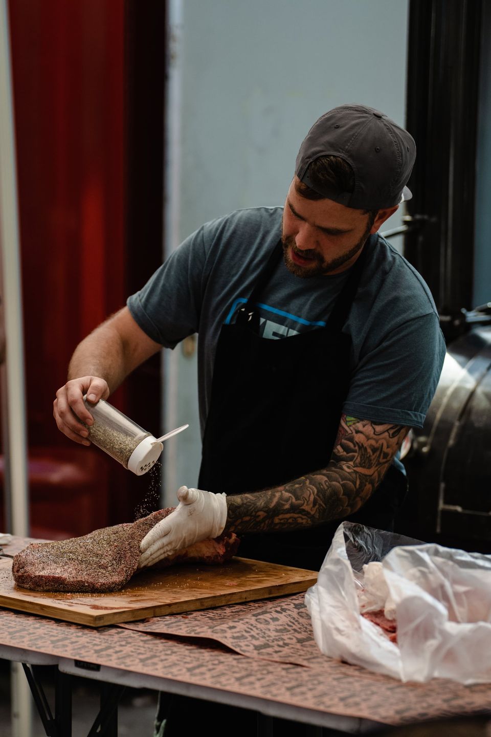 A pitmaster seasoning a brisket at a Wilson's BBQ class