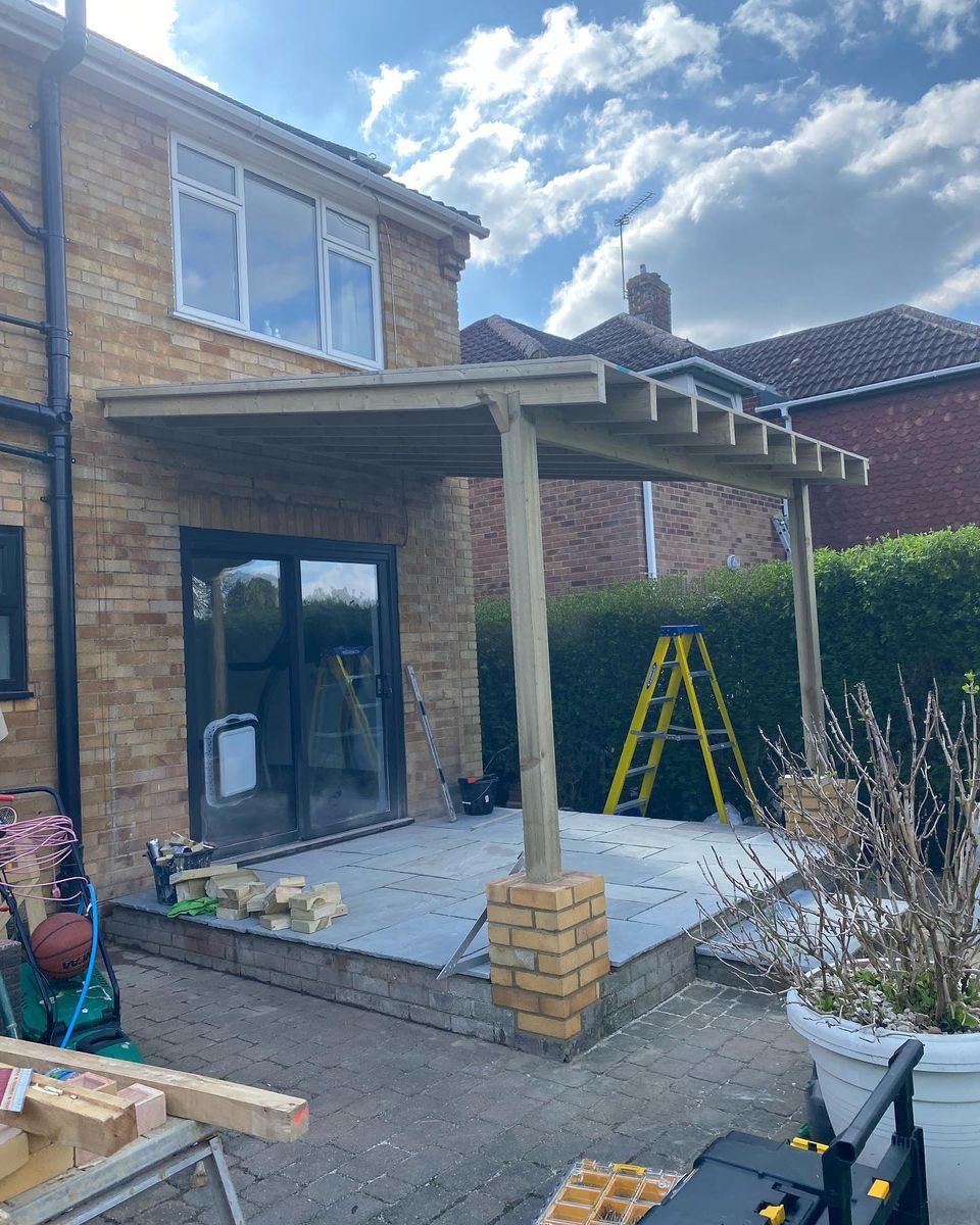 Patio area with timber pergola being built at rear of house